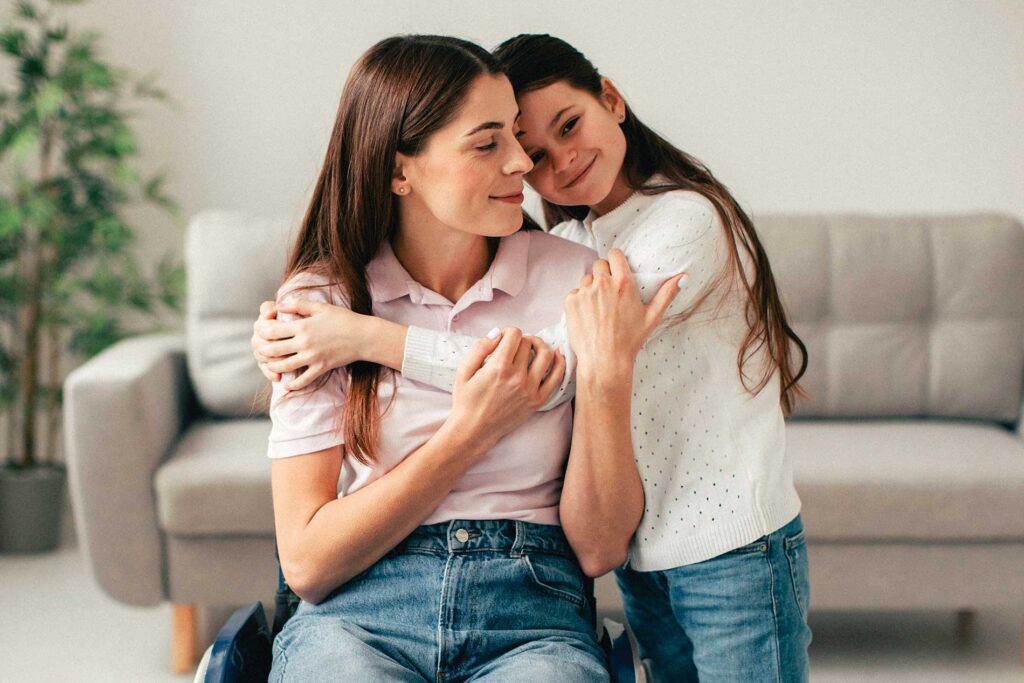 Niña abrazando a mujer joven de forma afectuosa