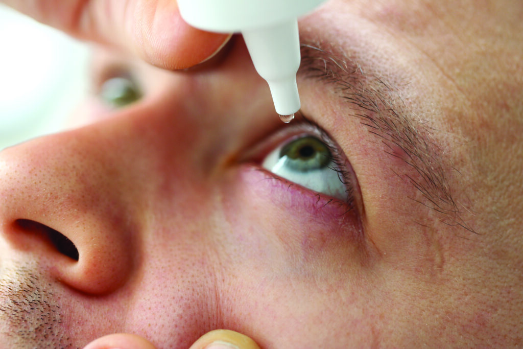 hombre aplicando medicina con gotero en el ojo, salud visual
