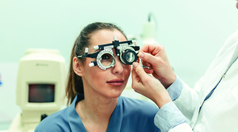 Ophthalmologist examining woman with optometrist trial frame. female patient to check vision in ophthalmological clinic.